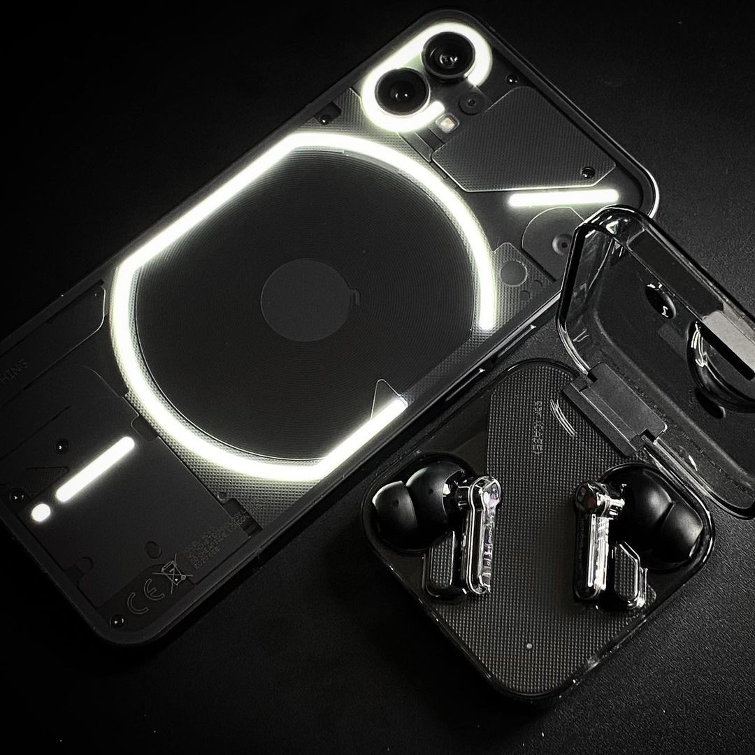 The Nothing Phone (1) and Nothing Ear (1) earbuds in black.