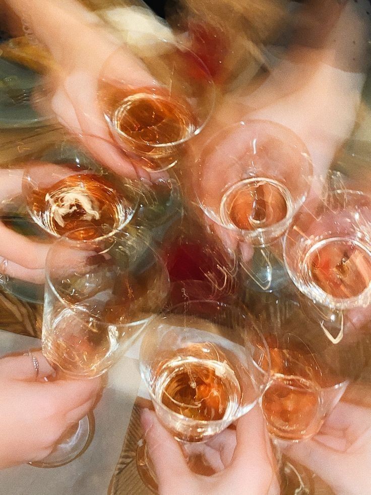 Viele Hände stoßen von oben gesehen mit Gläsern Rosé an